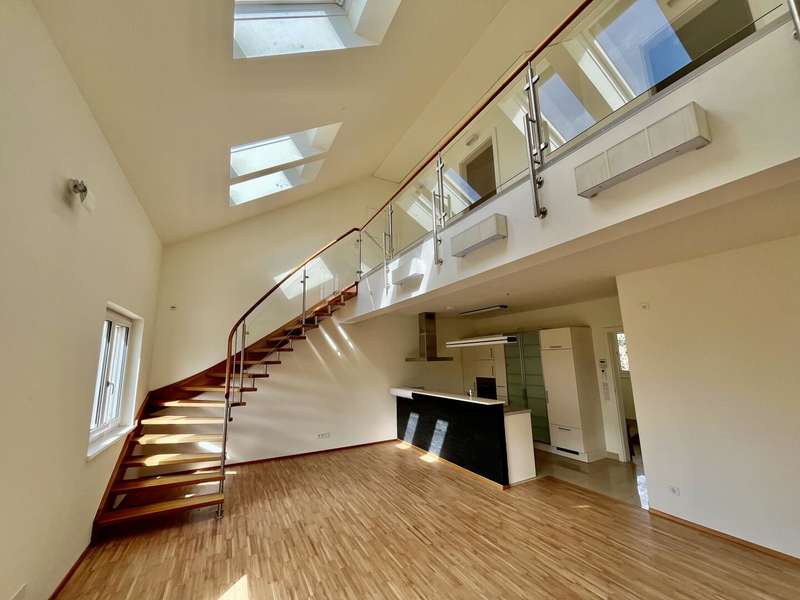 Wohnzimmer mit offener Küche und Galerie - Penthouse Graz - Bild 1